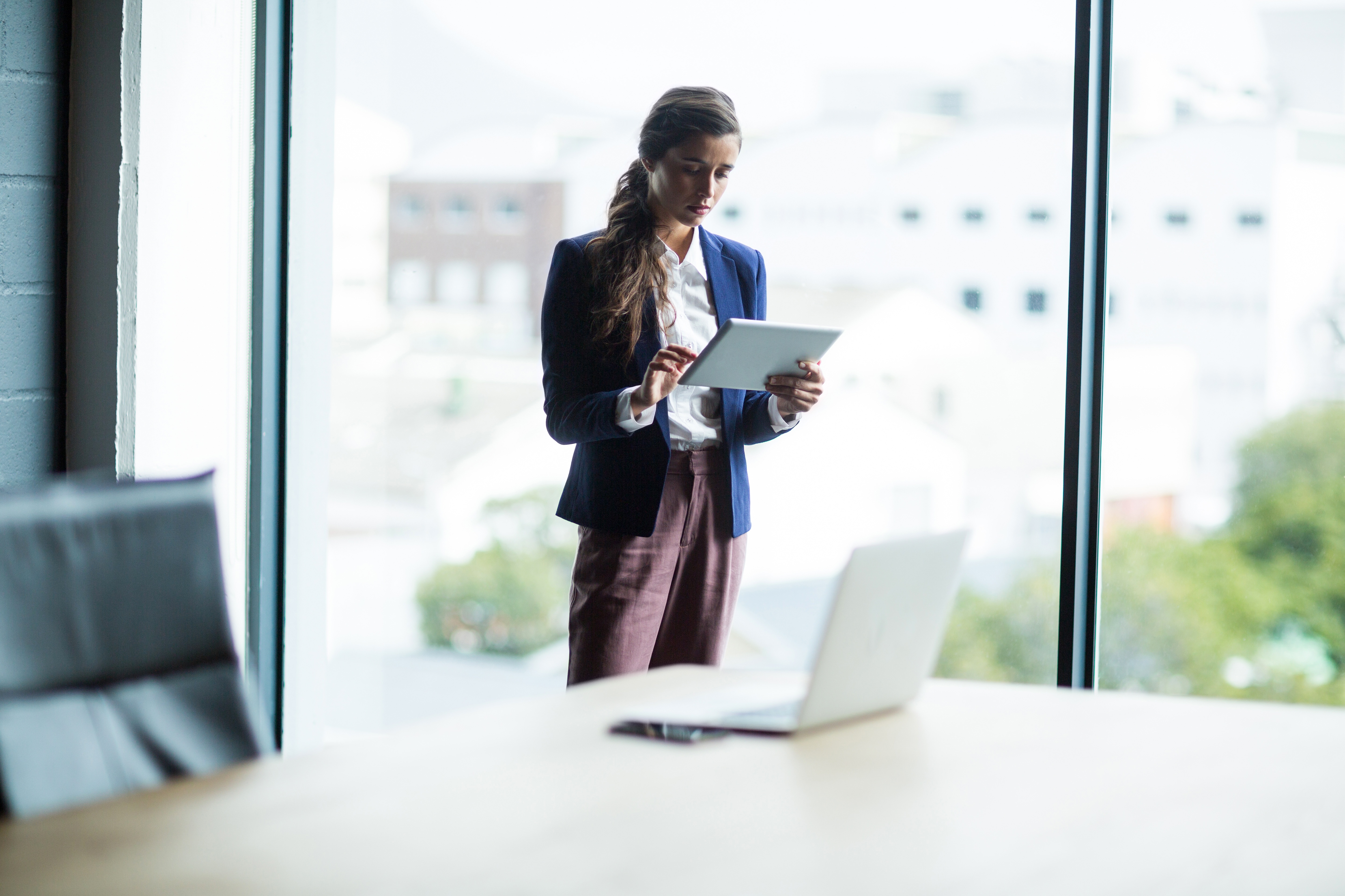 Consultant using a digital tablet to access AI-powered research insights in a modern office
