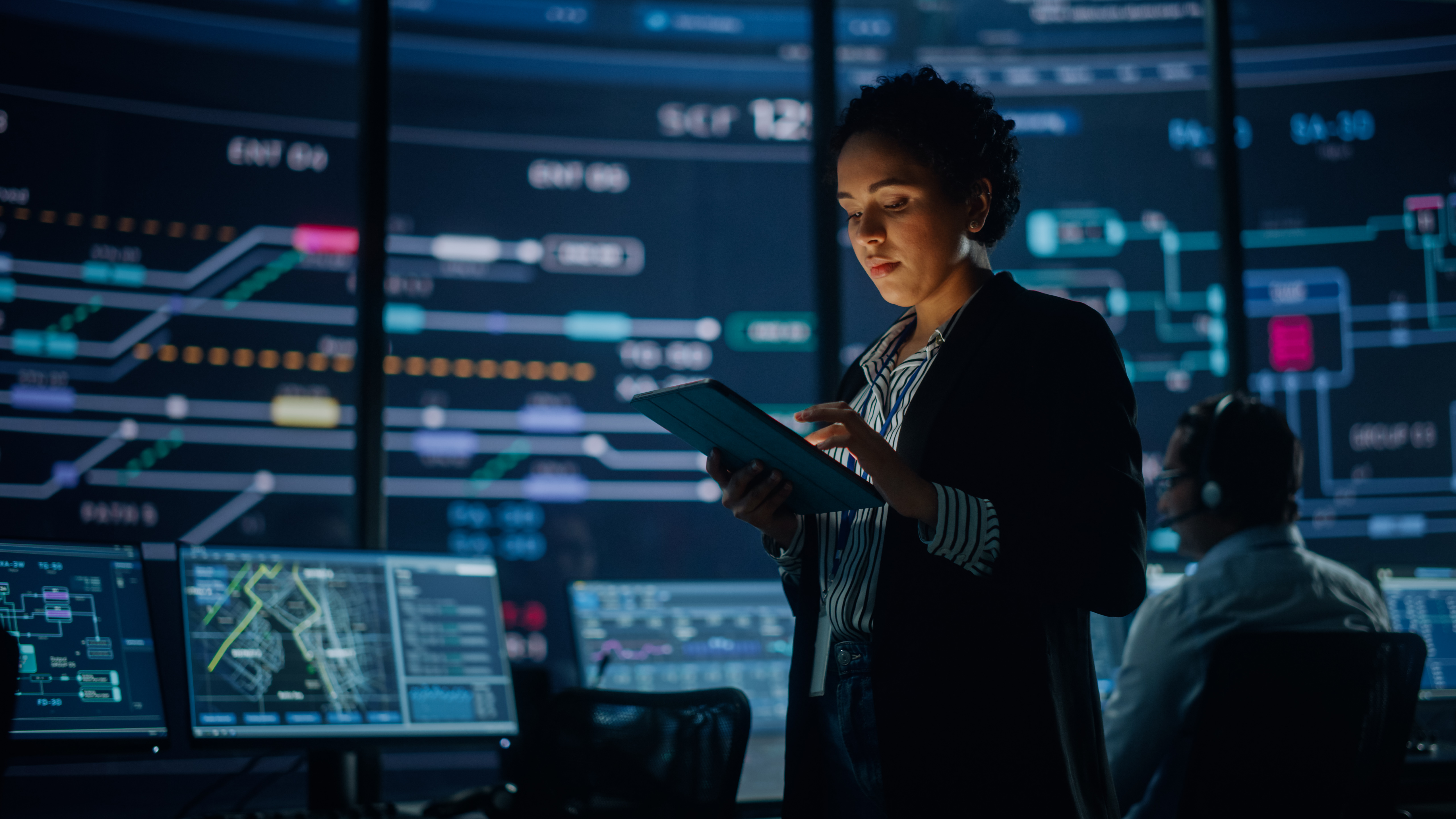 Enterprise analyst reviews agentic AI system performance on tablet in operations control center